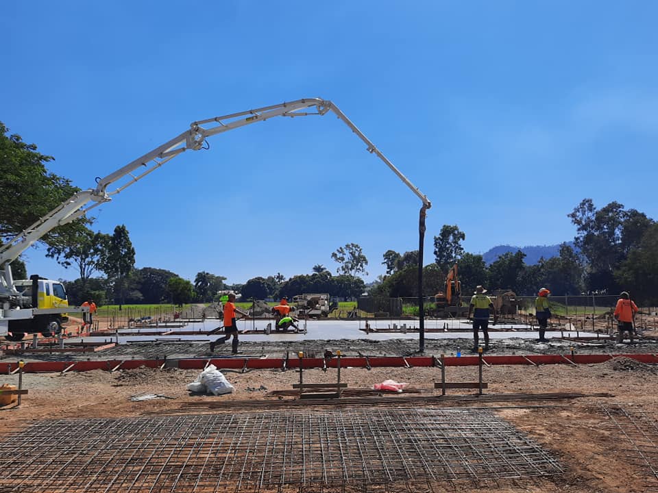 A concrete pump is being used to pour concrete on a construction site.
