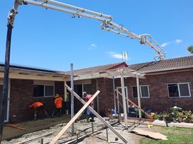 A group of construction workers are working on a brick house.