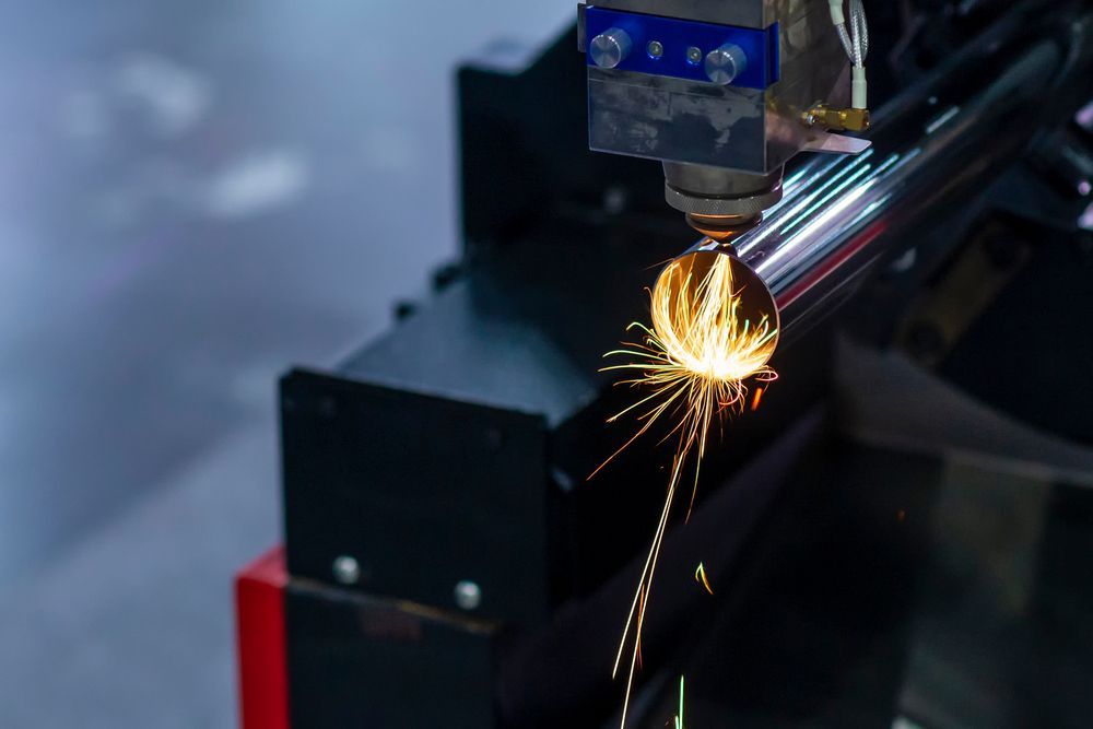 A Machine Is Cutting A Metal Pipe With Sparks Coming Out Of It — BM Steel Fabrication In Forster, NSW
