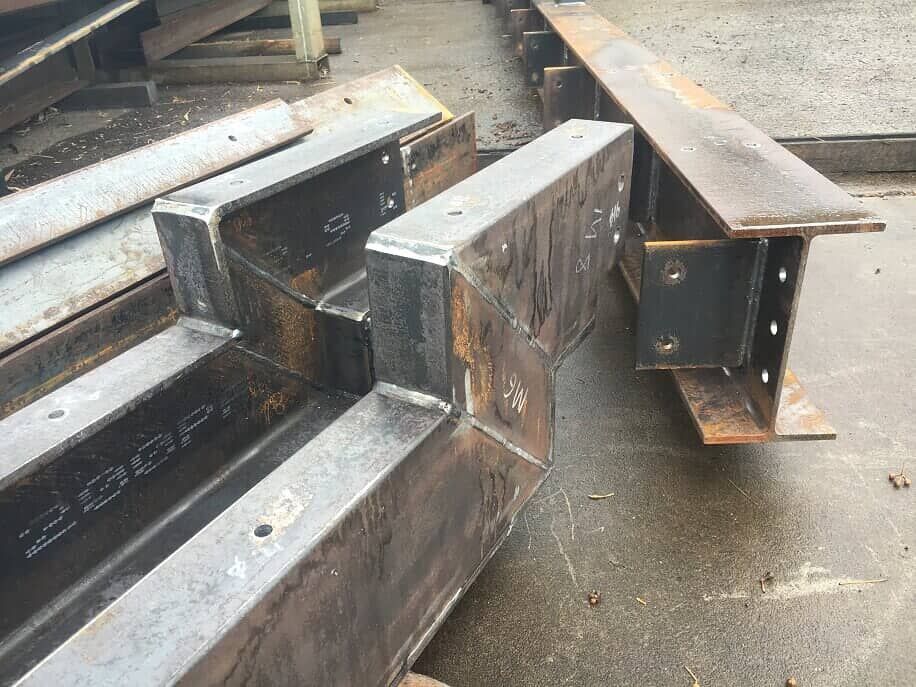 A bunch of metal beams are sitting on top of each other on the ground.
