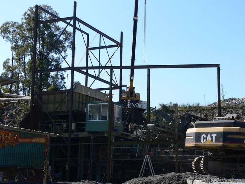 A Construction Site With A Cat Excavator In The Foreground — BM Steel Fabrication In Forster, NSW