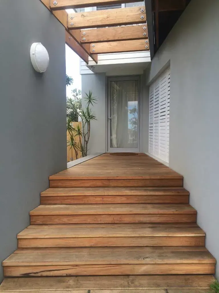 A Set Of Wooden Stairs Leading Up To A House — BM Steel Fabrication In Forster, NSW