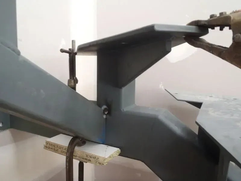 A Person Is Working On A Metal Staircase With A Wrench — BM Steel Fabrication In Forster, NSW