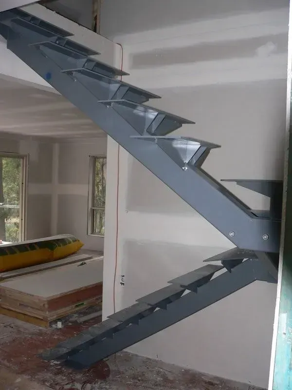 A Metal Staircase In A House Under Construction — BM Steel Fabrication In Forster, NSW