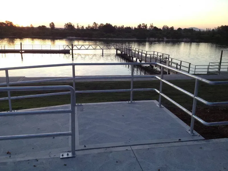 A Metal Railing Leading To A Dock Overlooking A Body Of Water — BM Steel Fabrication In Forster, NSW