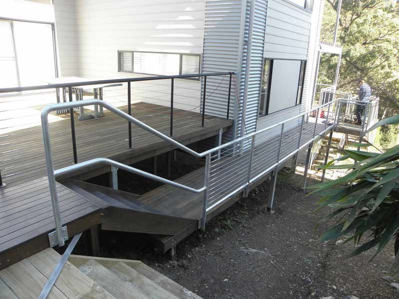 A Wooden Deck With Stairs Leading Up To It — BM Steel Fabrication In Forster, NSW