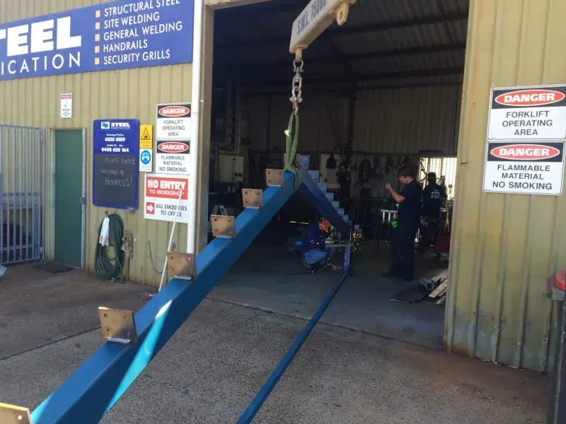 A Building With A Blue Sign — BM Steel Fabrication In Forster, NSW