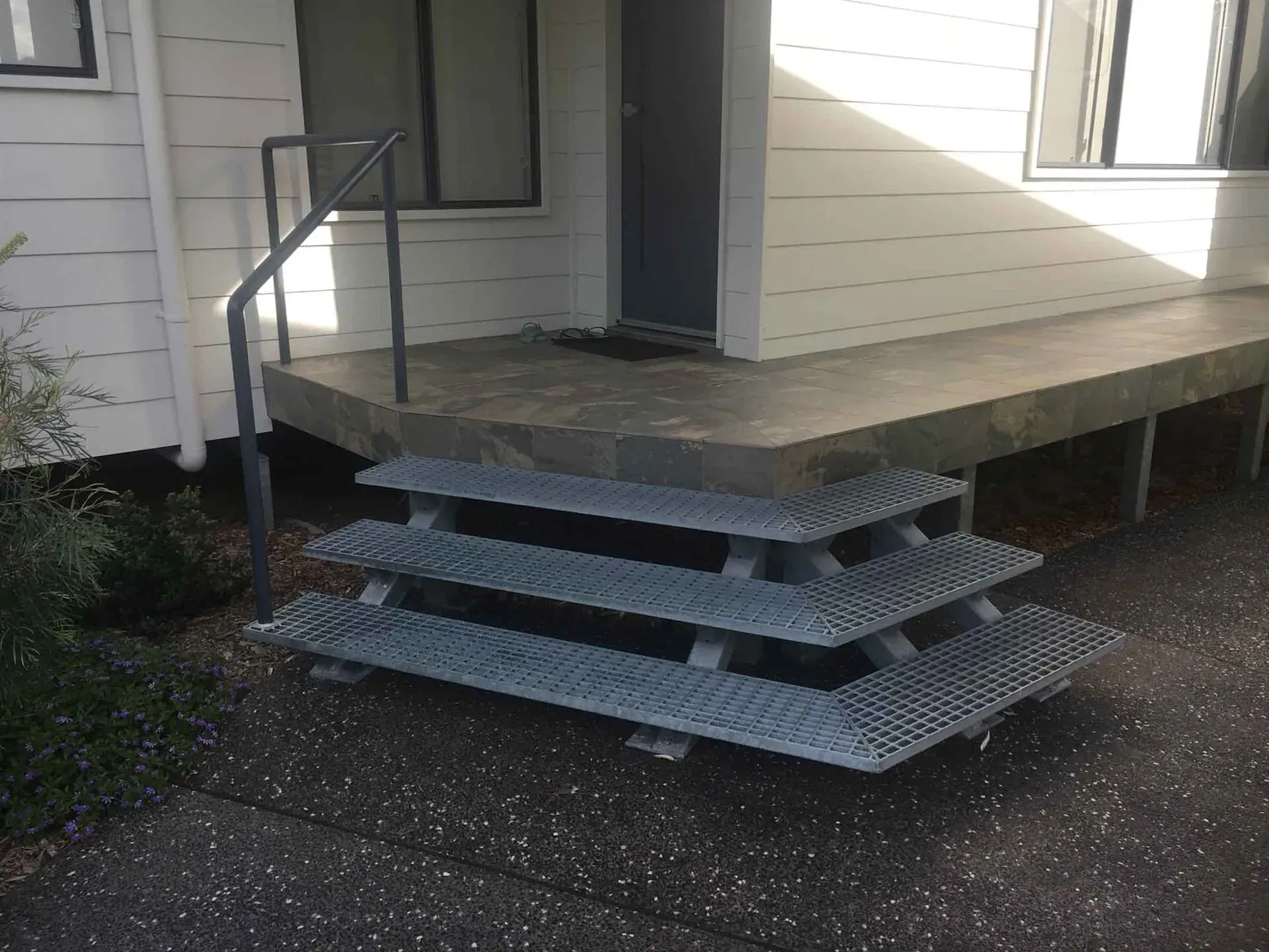 A Set Of Metal Stairs Leading Up To A Porch Of A House — BM Steel Fabrication In Forster, NSW