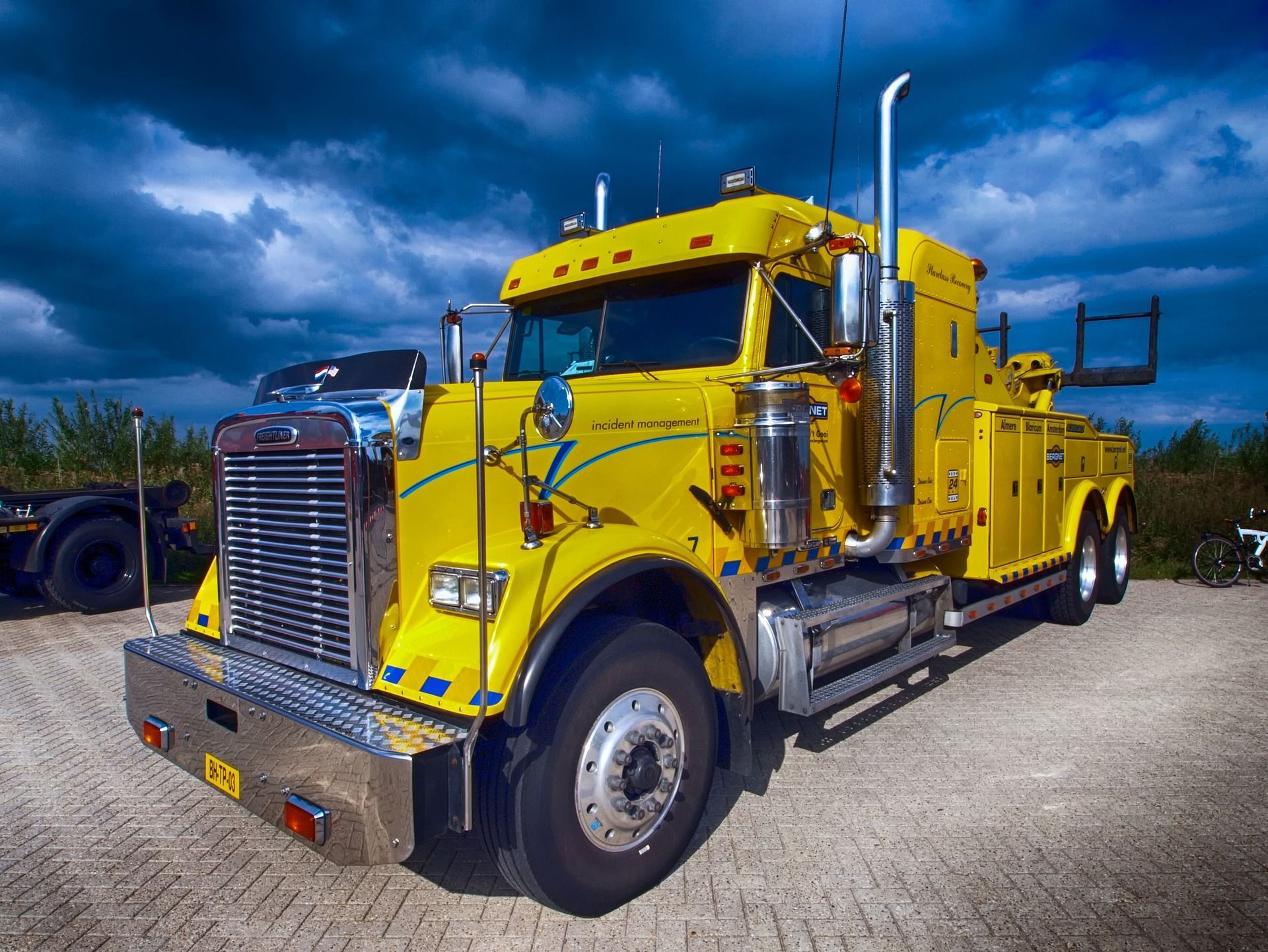 A yellow tow truck is parked in a parking lot.