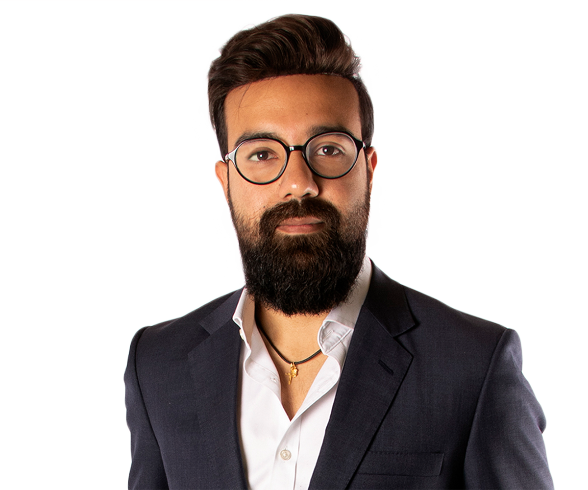 A man with a beard and glasses is wearing a suit and white shirt.