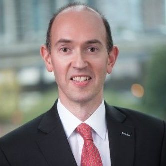 A man in a suit and tie is smiling for the camera.