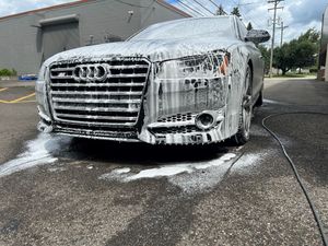 An audi a8 is covered in foam while being washed.