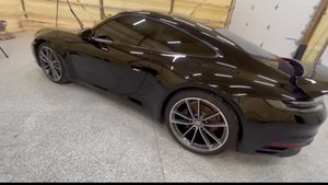 A black sports car is parked in a garage.