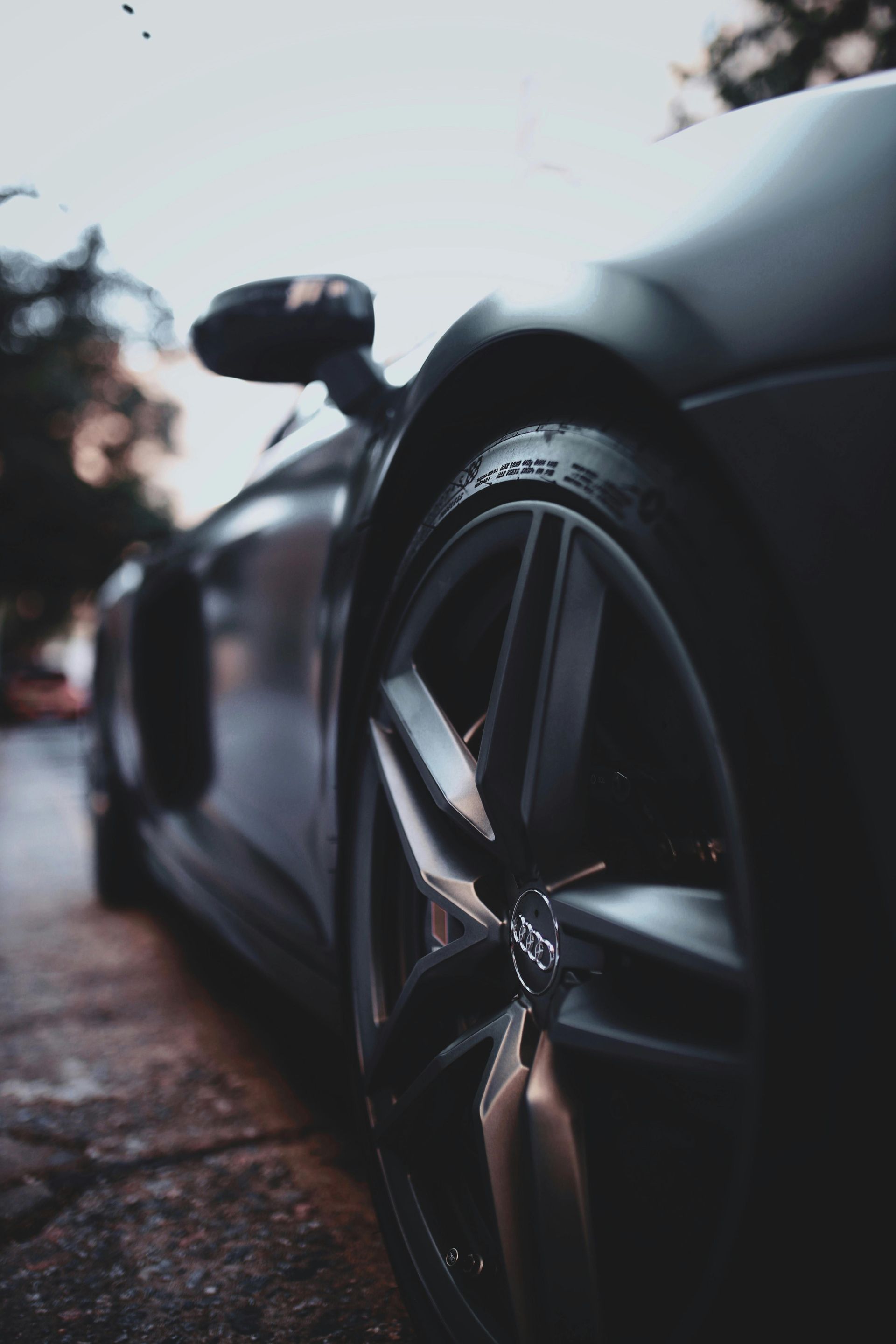 A close up of a car 's wheel on a street.