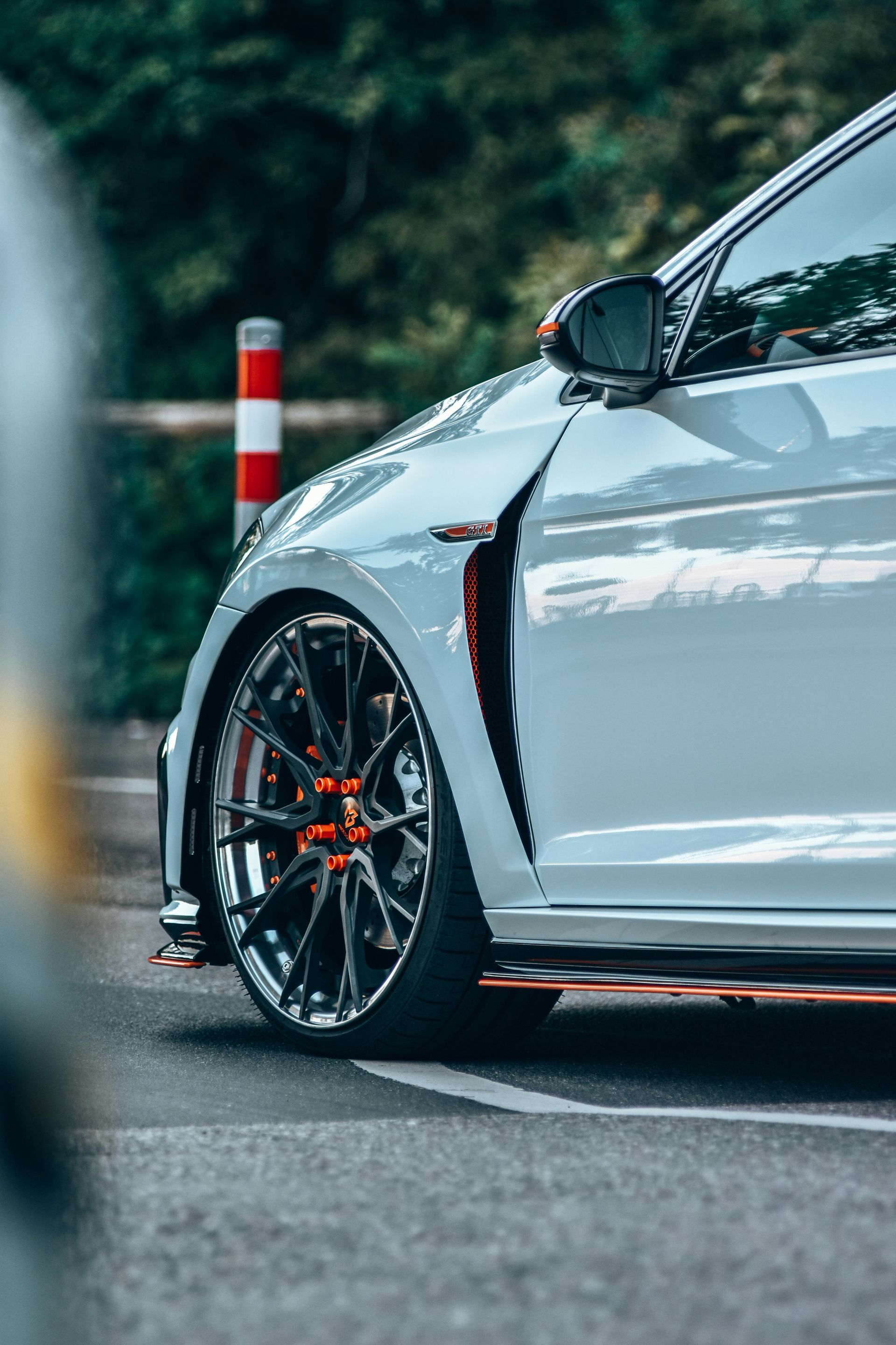 A close up of a silver car parked on the side of the road.