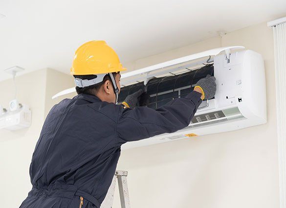 Worker Cleaning Air Conditioner — Honolulu, HI — Air Conditioning Experts