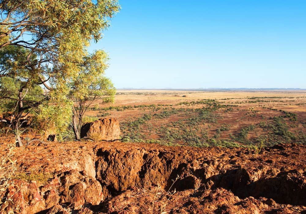 A Tree Stands on Top of a Rocky Hill Overlooking a Desert Landscape — Shaine Hunter Locksmiths in Winton, QLD