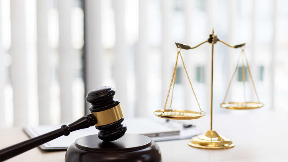 Gavel and scales of justice on a desk, symbolizing law and legal proceedings.