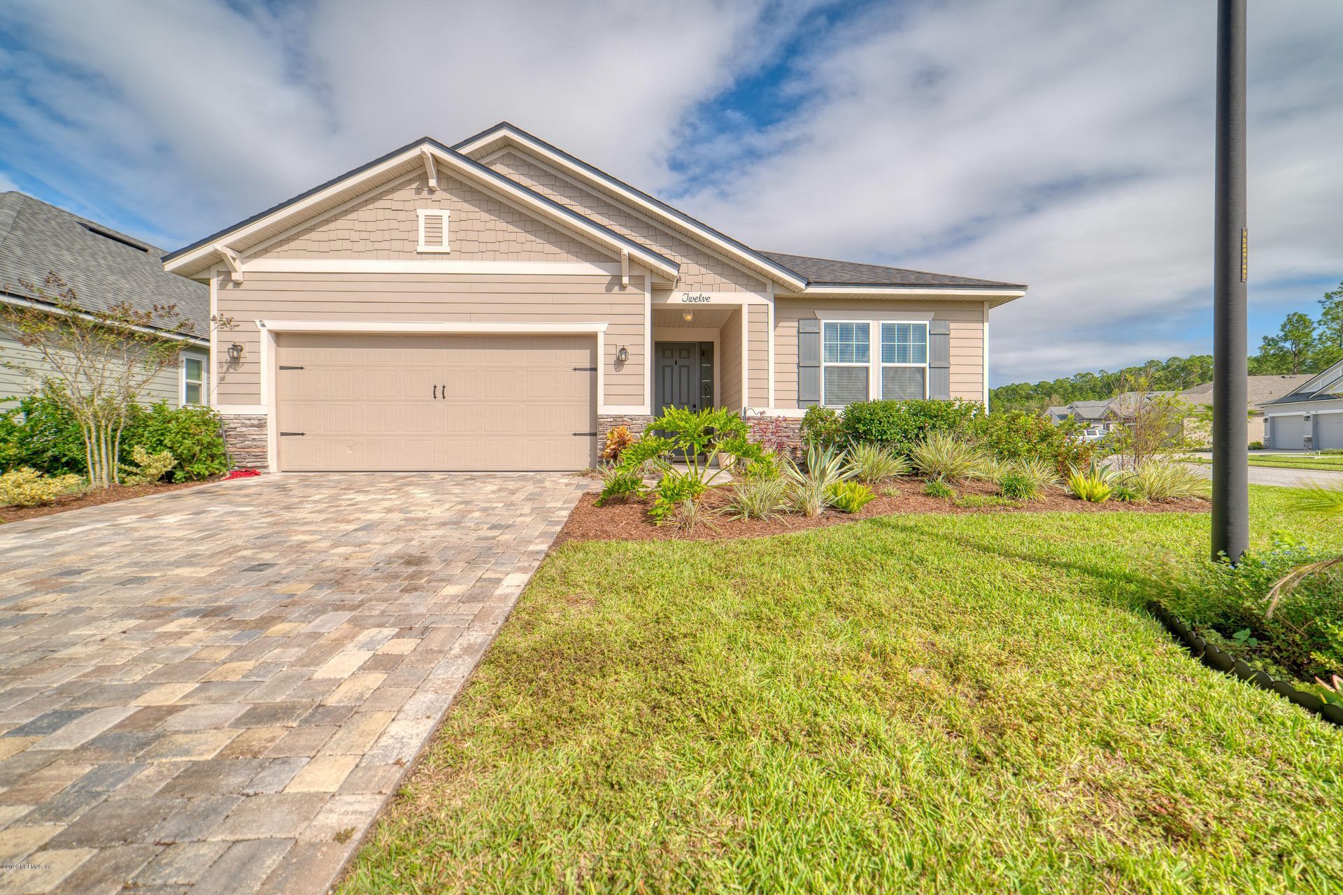 A little girl is carrying a cardboard box in front of a family.