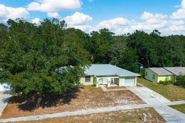 A boy and a girl are playing in a cardboard box in a living room.
