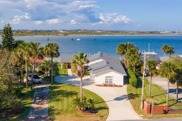 A kitchen with white cabinets , wooden floors , stools and a large island.