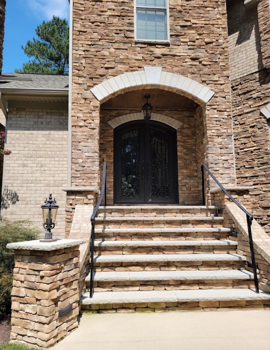 A Brick House With Stairs Leading Up to the Front Door
