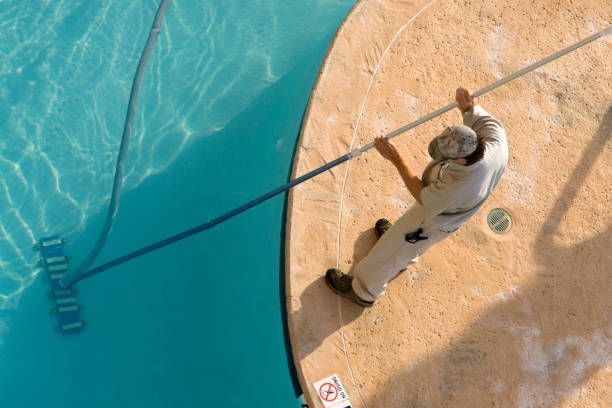 Overhead view of a technician vacuuming a pool.
