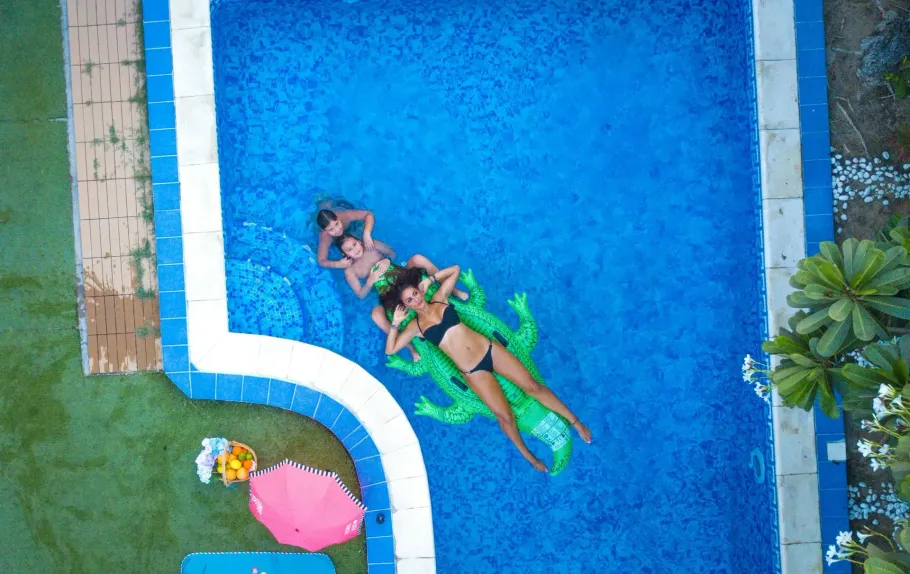 Aerial view of people relaxing in a blue swimming pool.