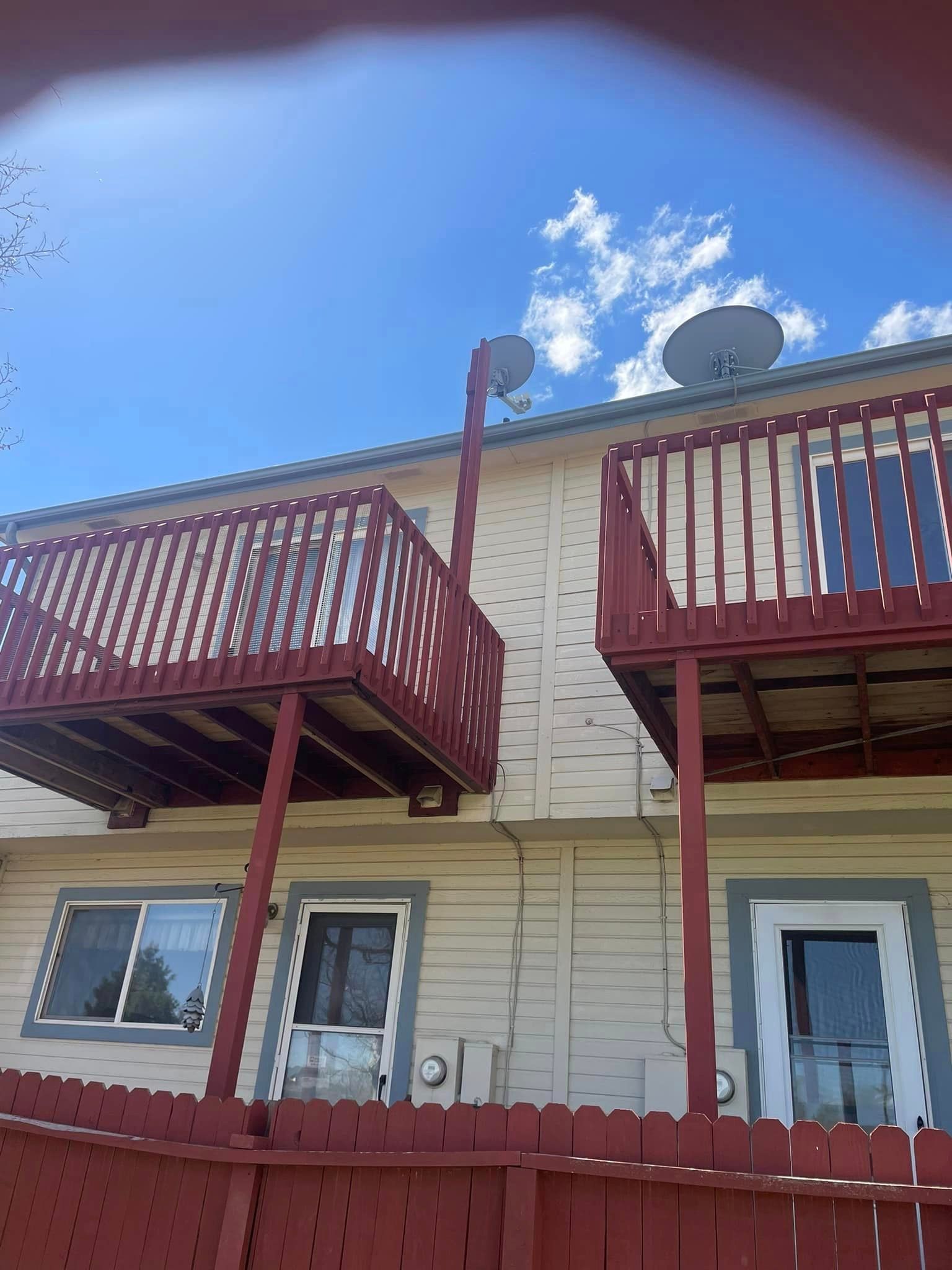 A house with two balconies and a red fence