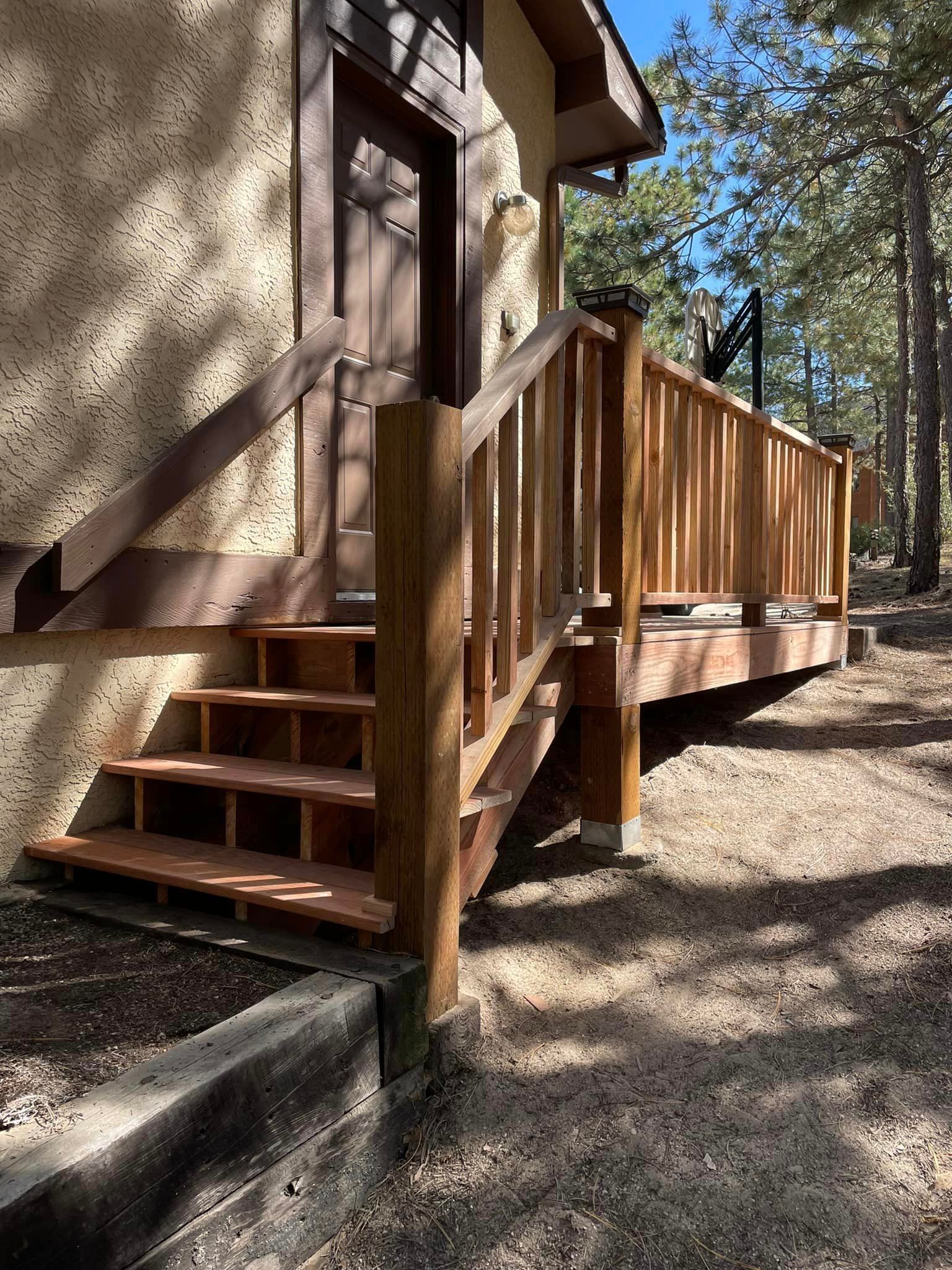 A house with a wooden deck and stairs leading up to it.