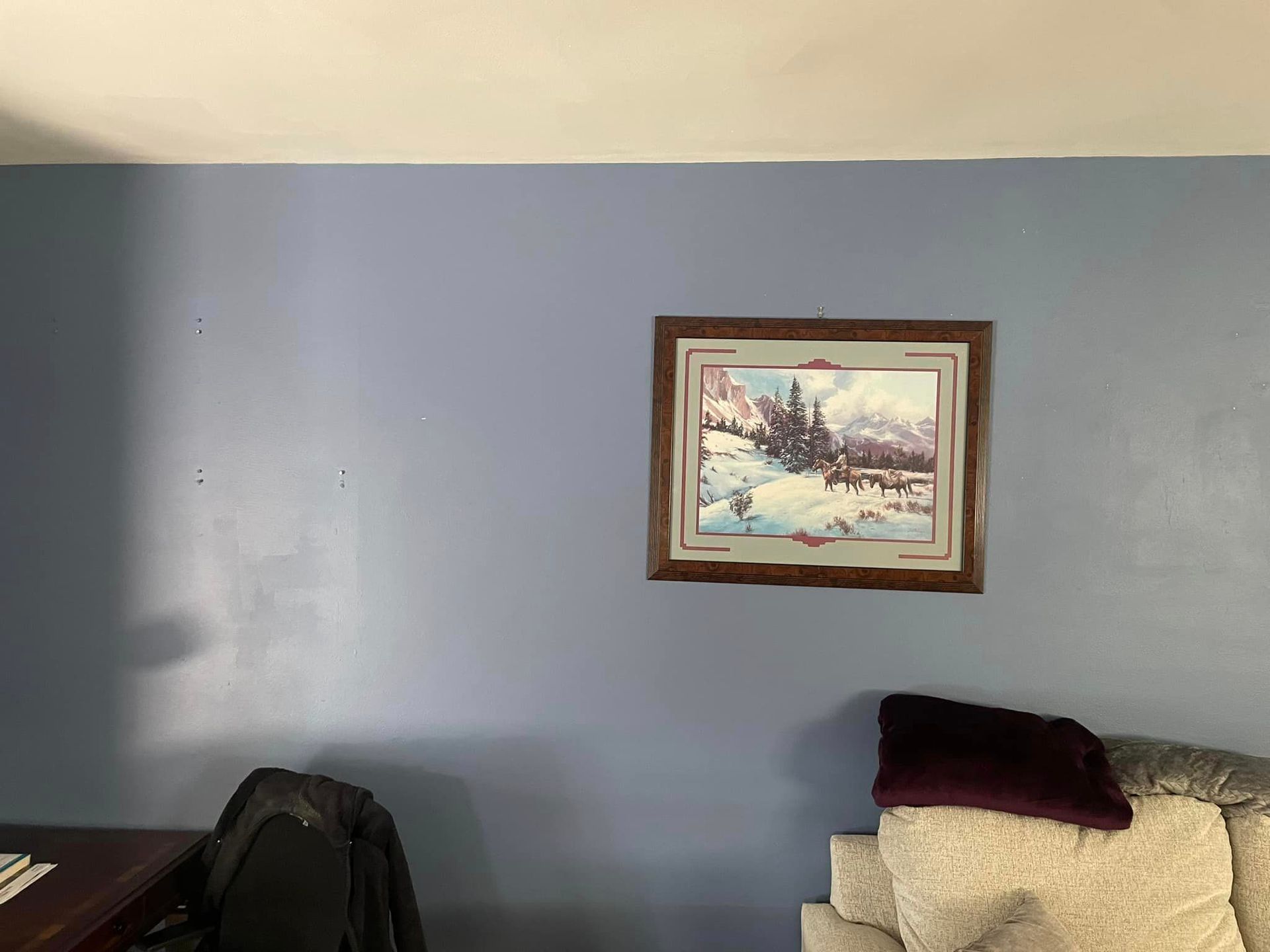 A painting is hanging on a wall in a living room.