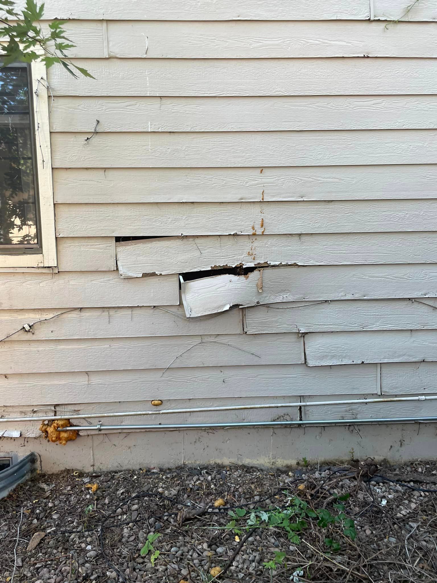 A white house with a hole in the side of it.