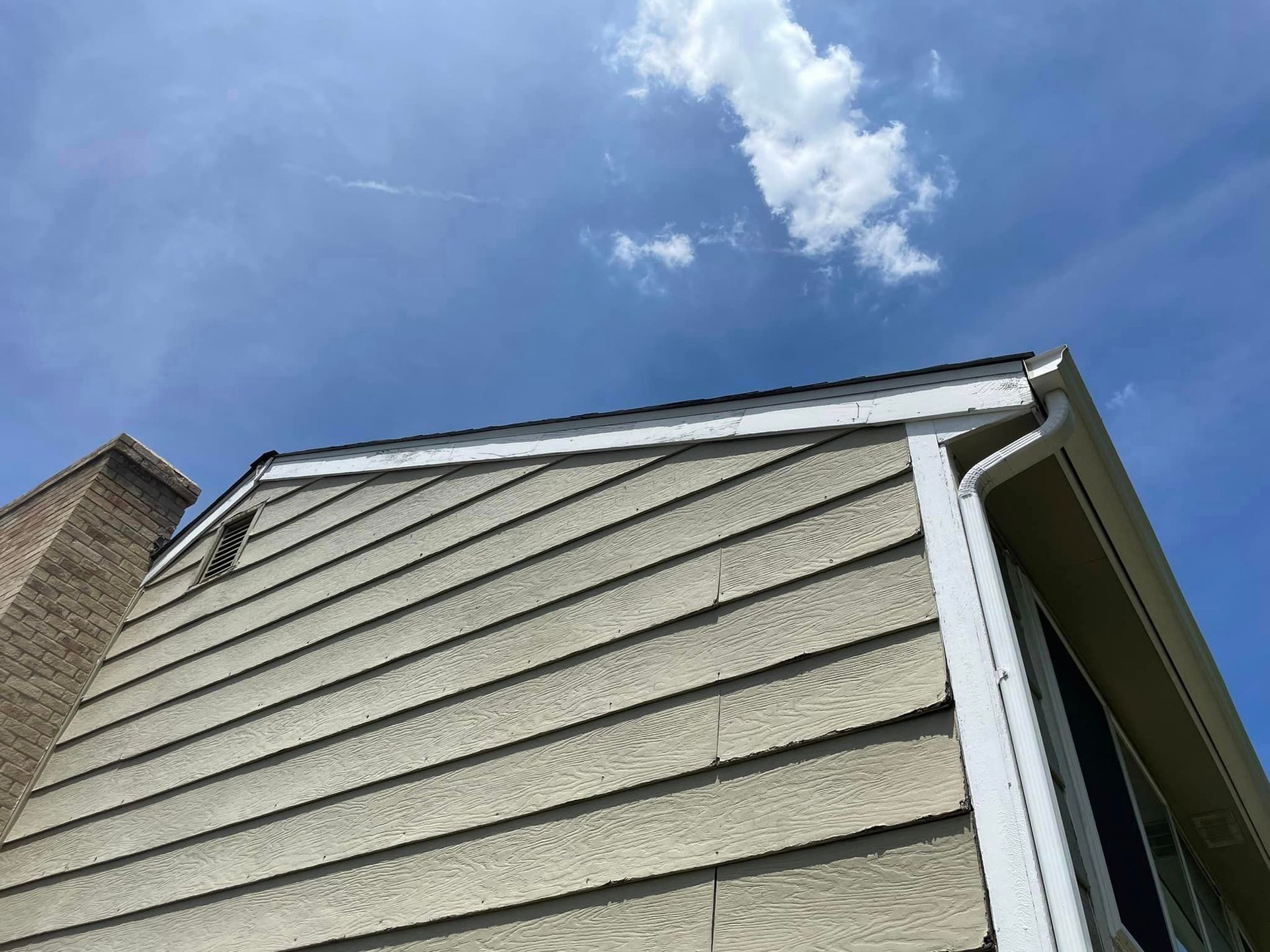 A house with a chimney and a blue sky in the background.