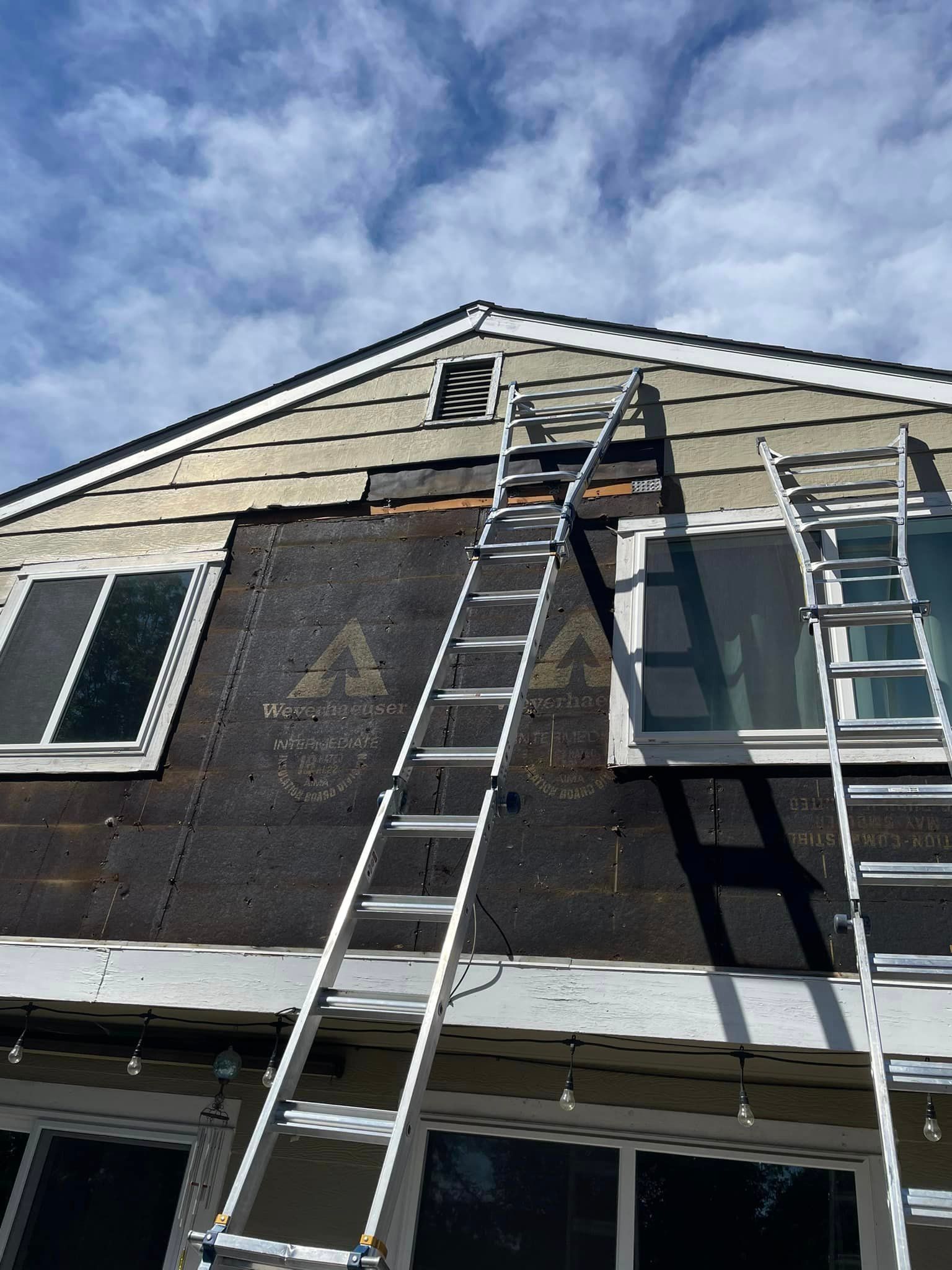 A ladder is sitting on the side of a house.