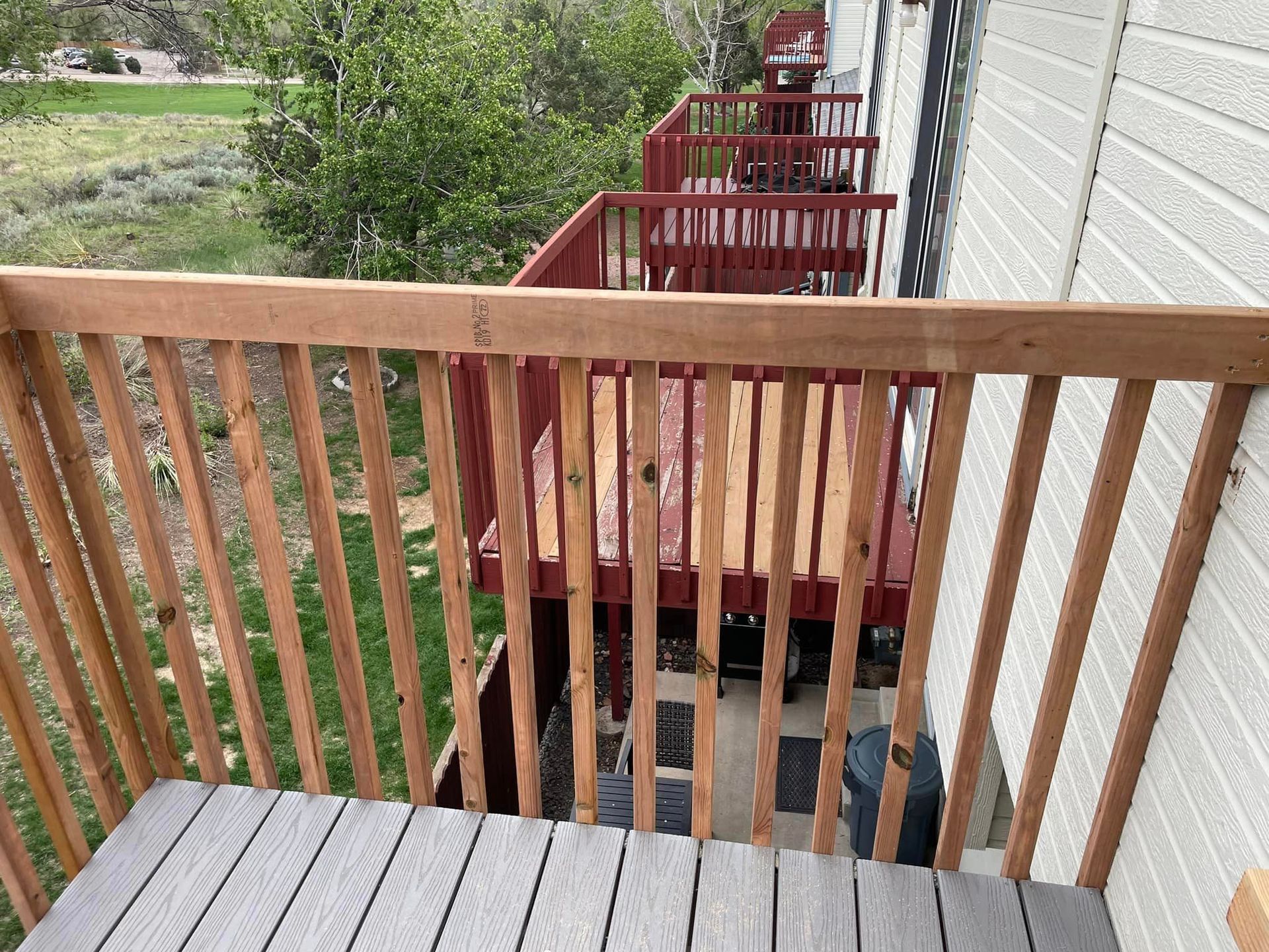 A balcony with a wooden railing and stairs leading up to it.
