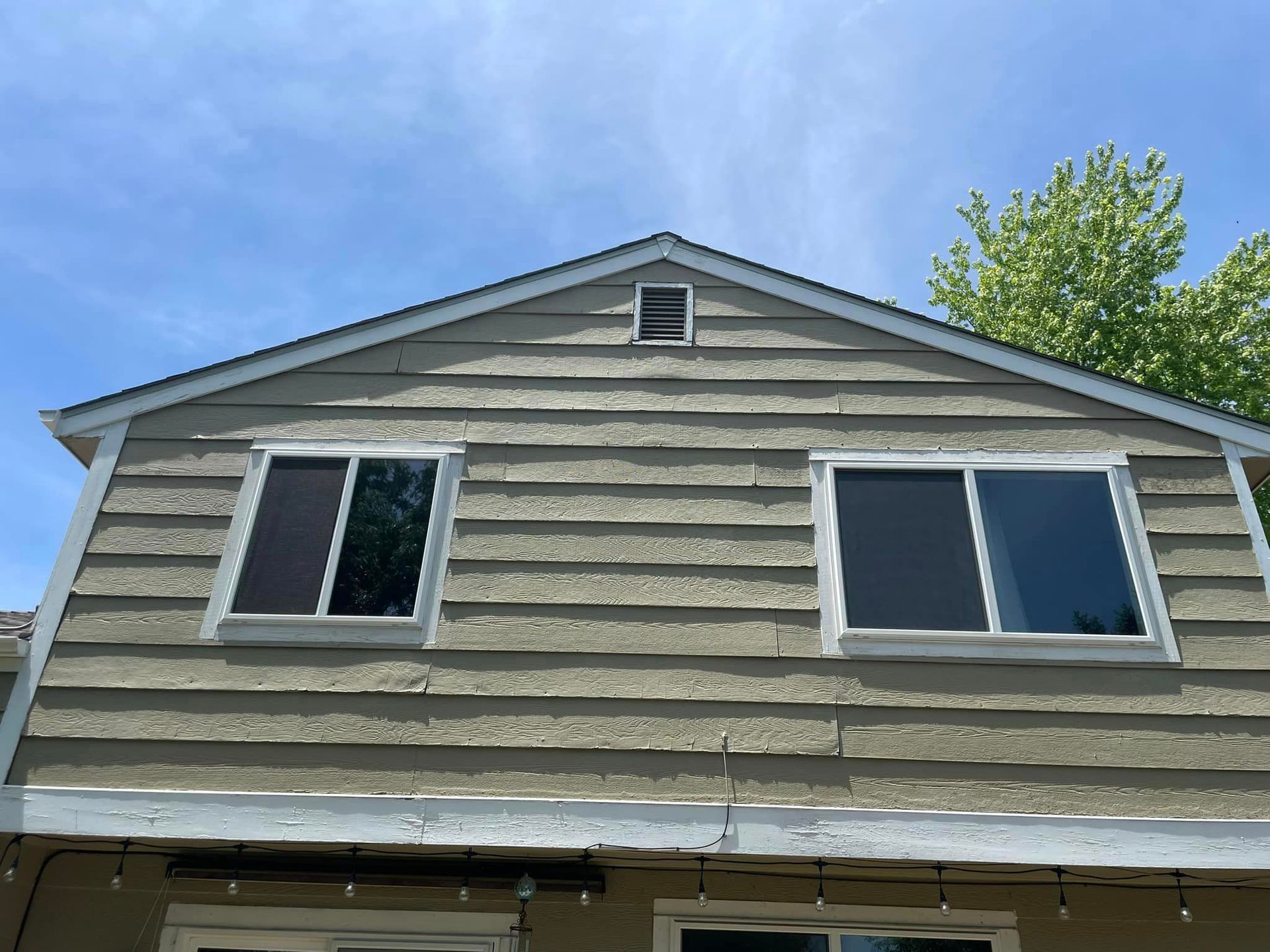 A house with a lot of windows and a blue sky in the background.