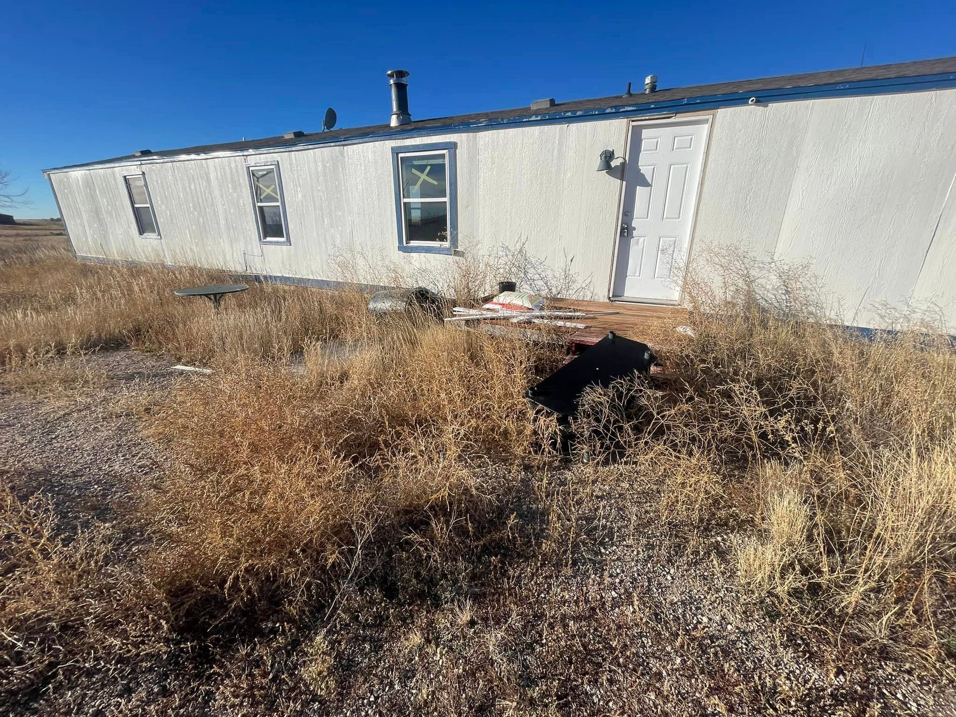 A white house is sitting in the middle of a field.