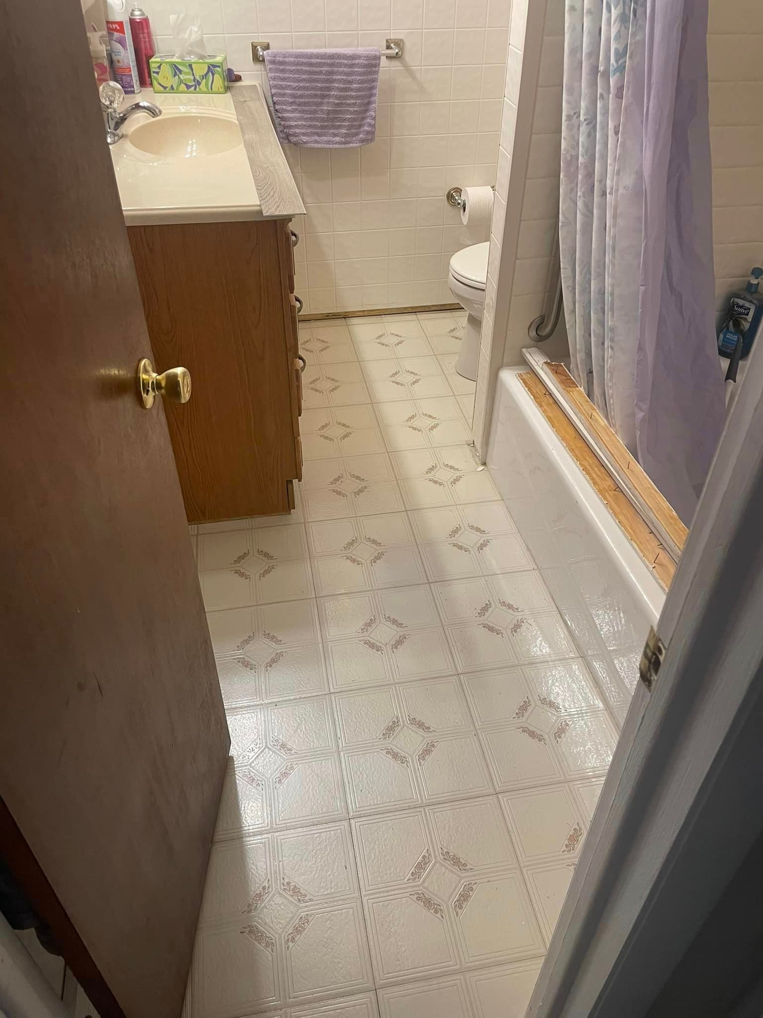 A bathroom with a sink , toilet , bathtub and shower curtain.