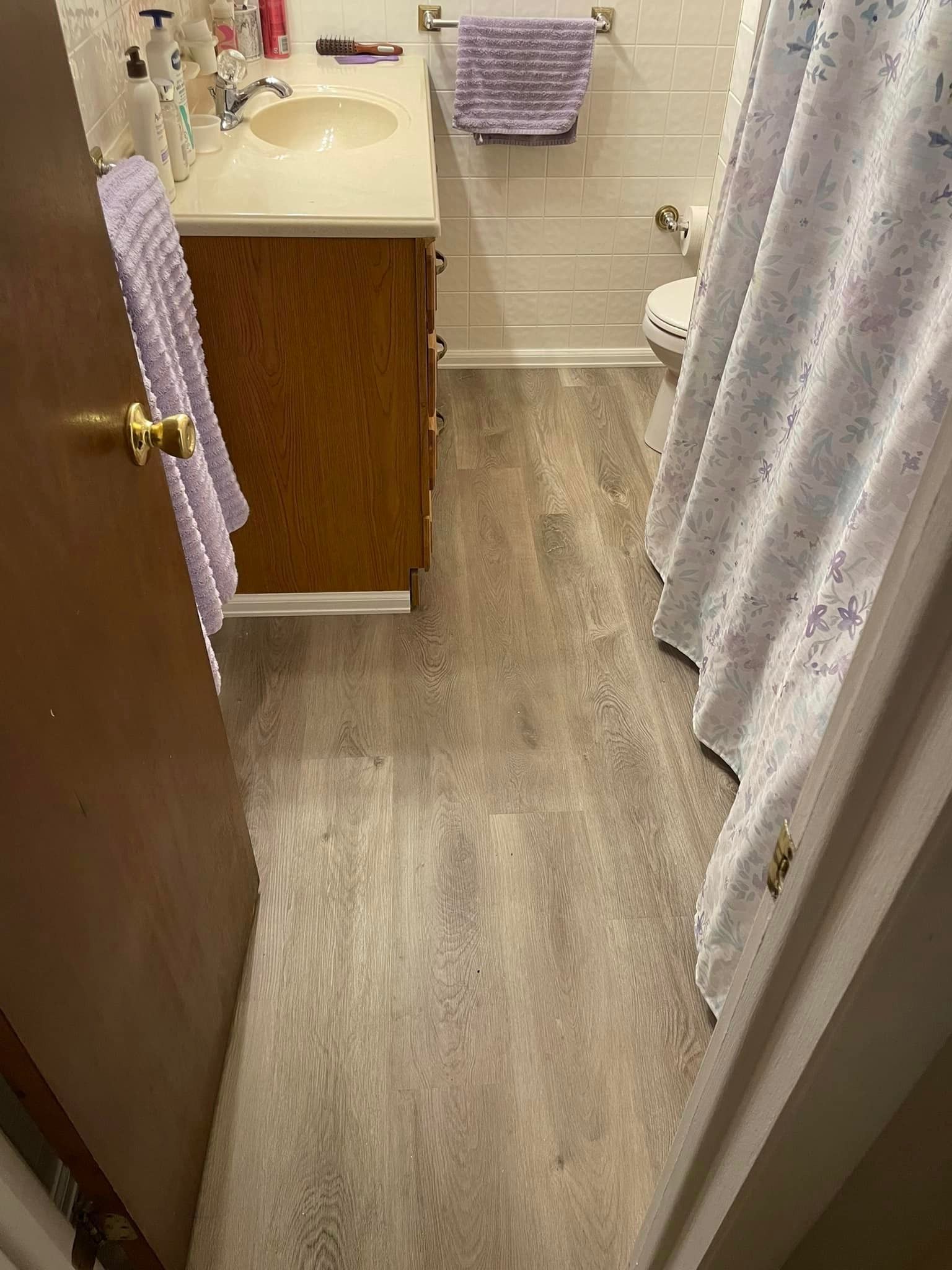 A bathroom with a sink , toilet and shower curtain.