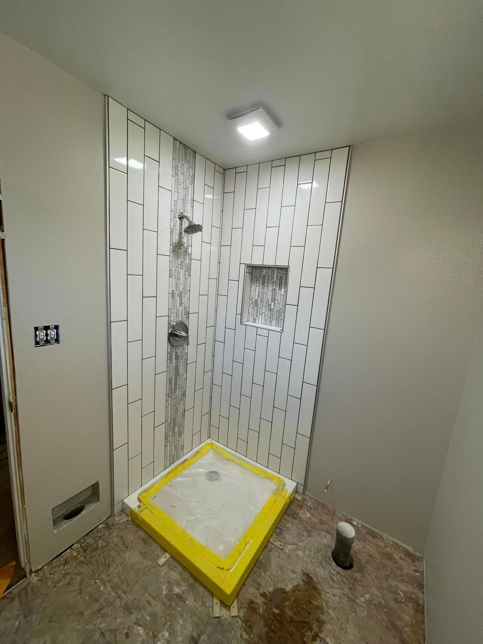 A shower stall is being built in a bathroom.