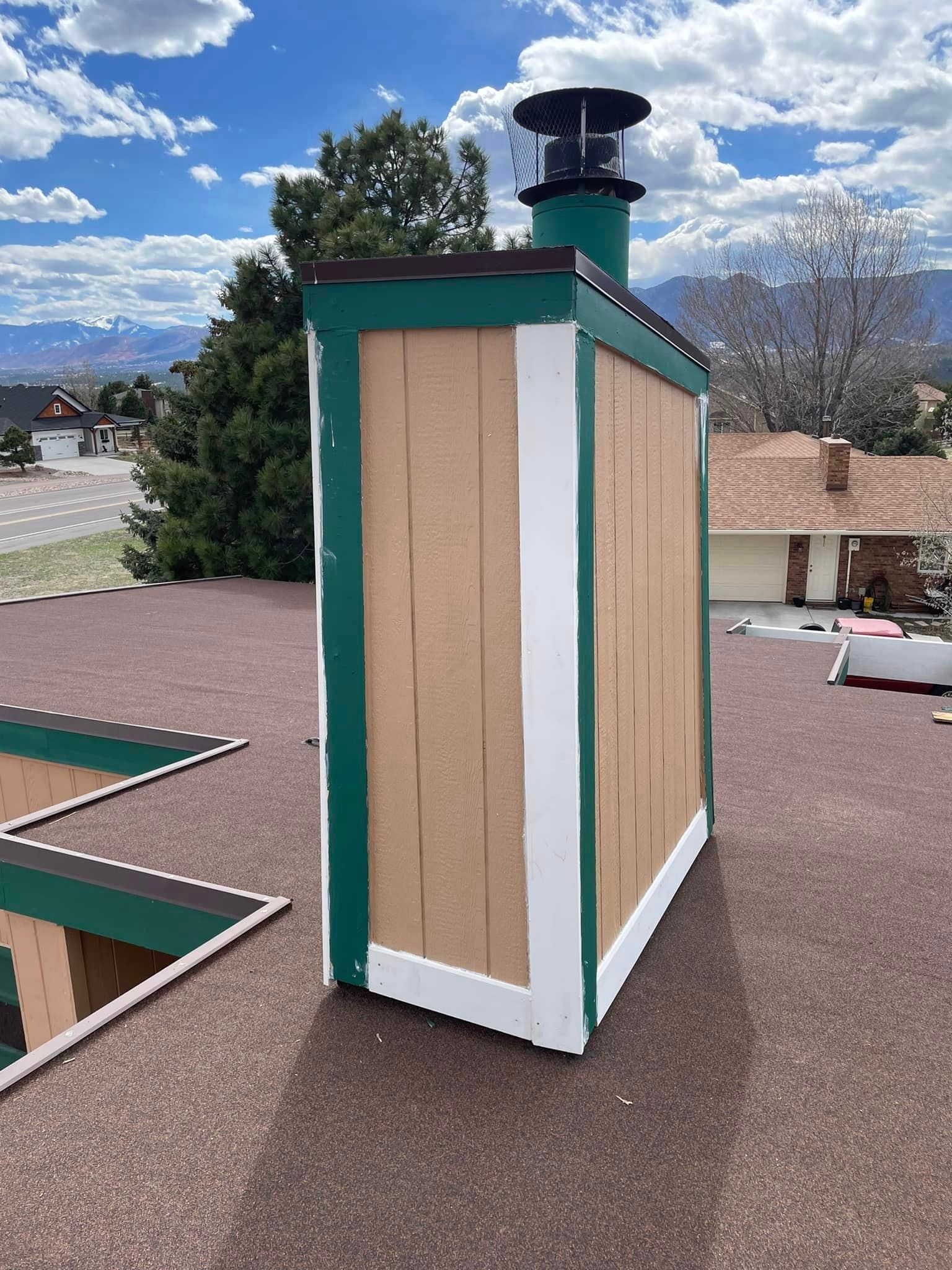 A wooden chimney is sitting on top of a roof.