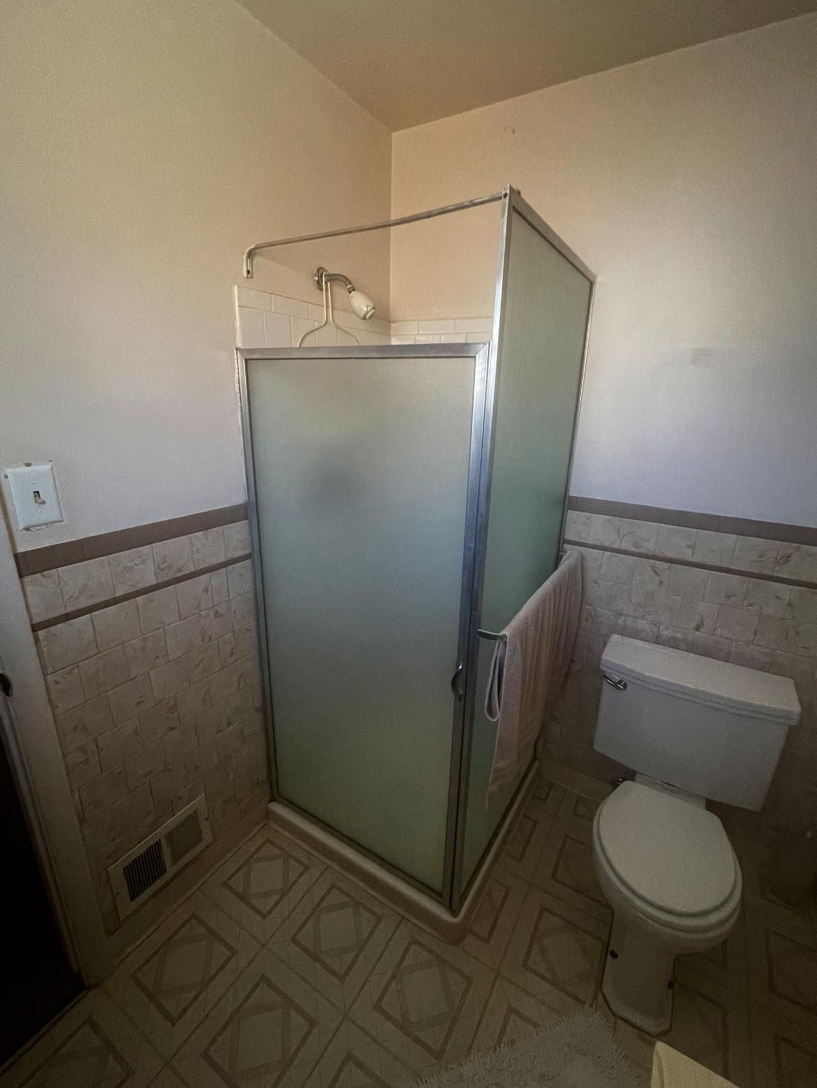 A bathroom with a toilet and a shower stall