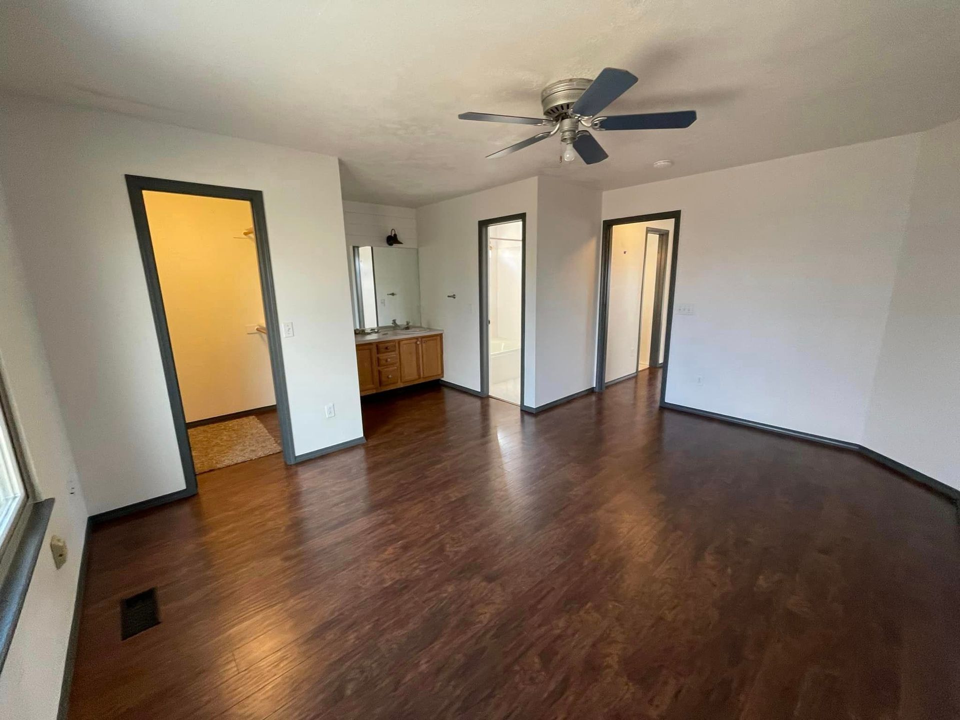 A living room with hardwood floors and a ceiling fan.