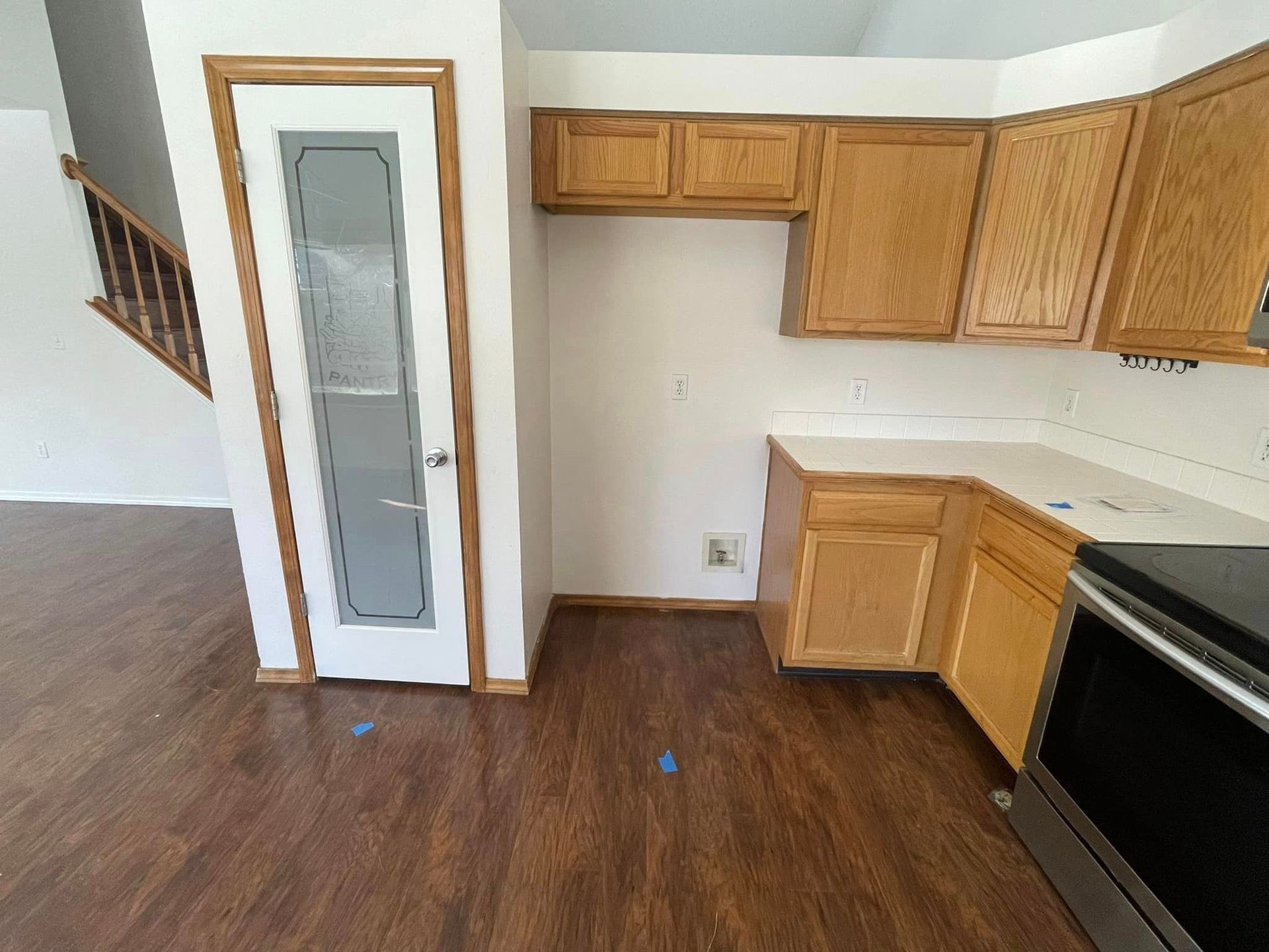 An empty kitchen with wooden cabinets and stainless steel appliances
