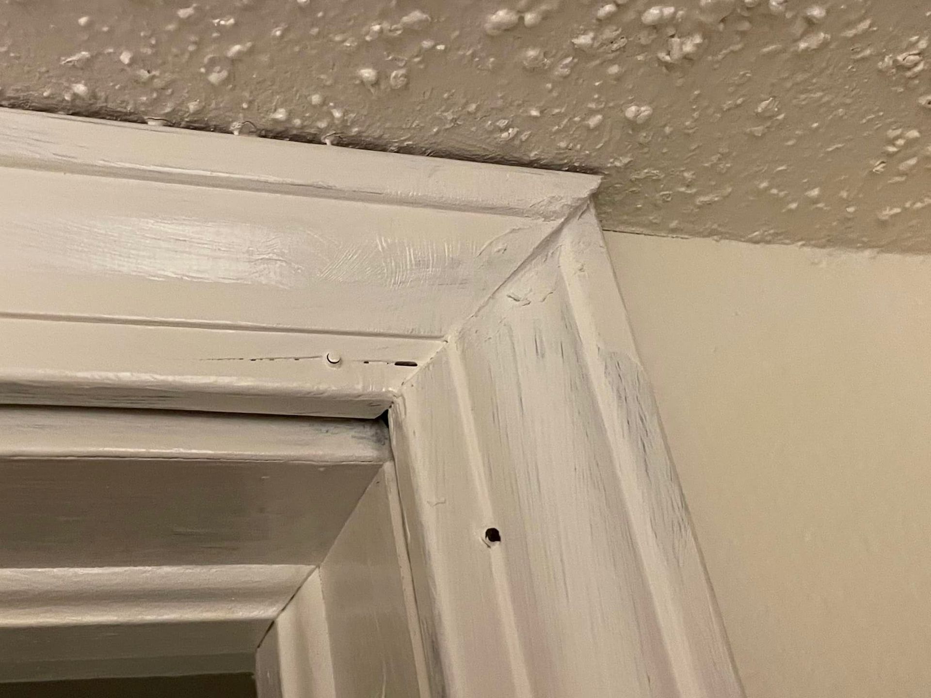 A close up of a door frame with a ceiling in the background.