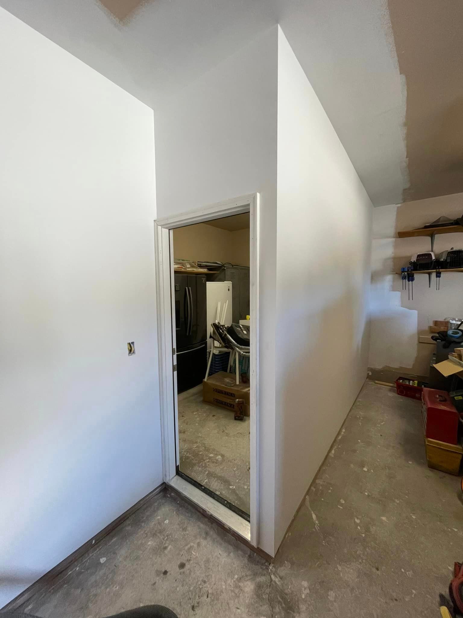 A room with white walls and a door that is open.