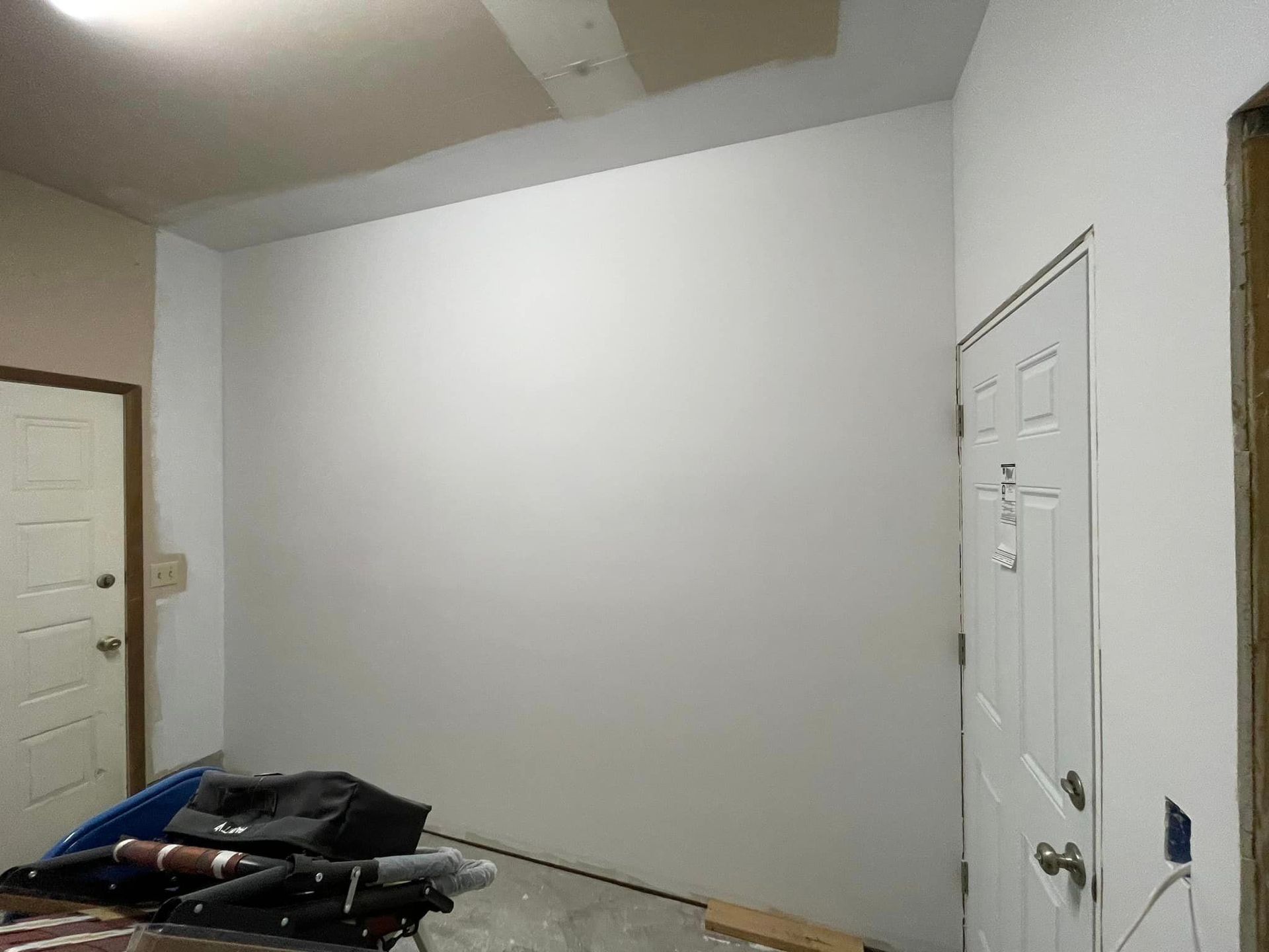 A room with a white wall and a door.