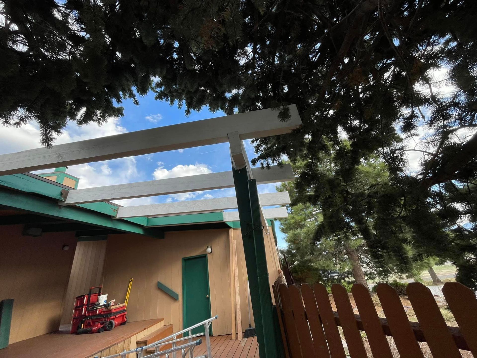 A house with a pergola and a fence in front of it