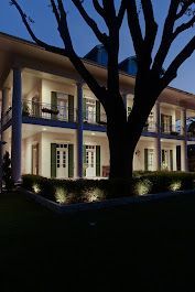 A large house with a tree in front of it at night.