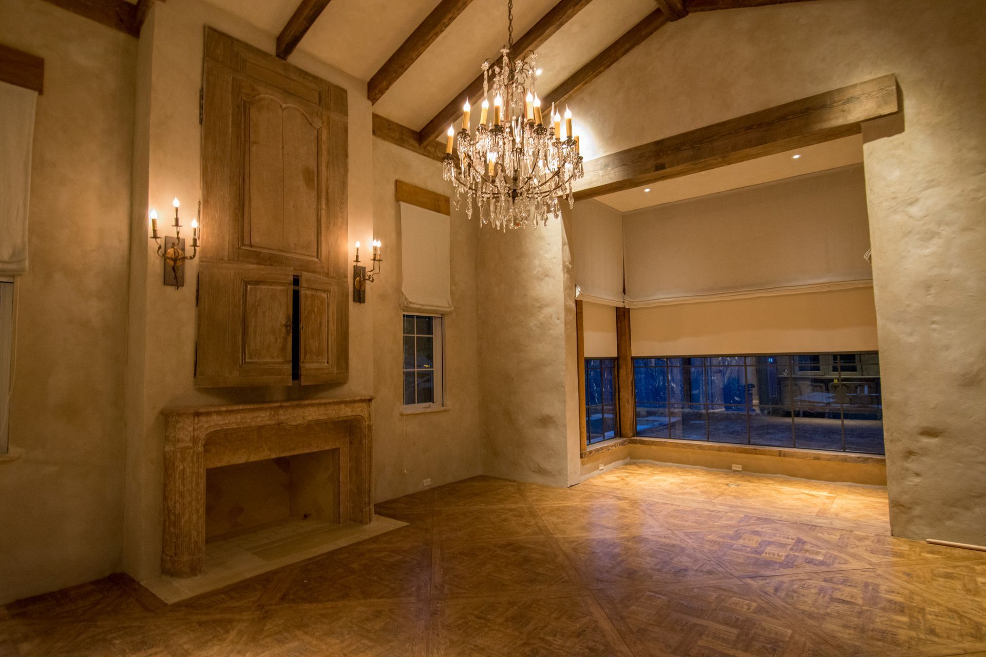 An empty living room with a fireplace and a chandelier.